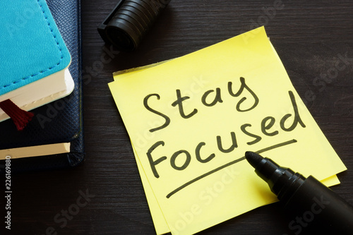 Stay focused handwritten on a memo stick and notepad.