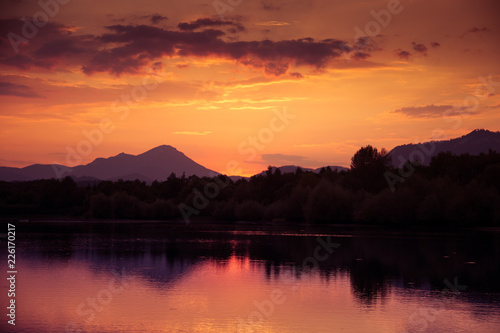 A beautiful  colorful sunset over the mountains  lake and forest in purple tones. Abstract  bright landscape. Tatra mountains in Slovakia  Europe.