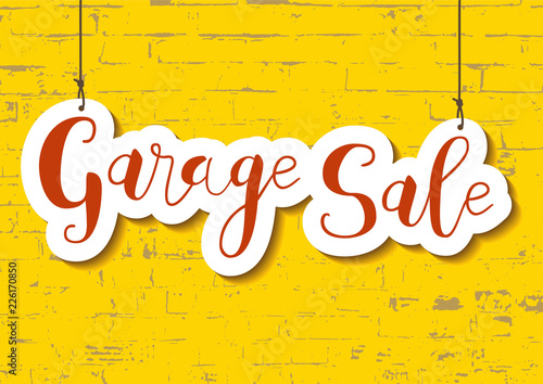 Calligraphy lettering of Garage sale in orange in paper cut style on yellow textured brick wall background for advertising, invitation, banner, poster, flyer, handbill
