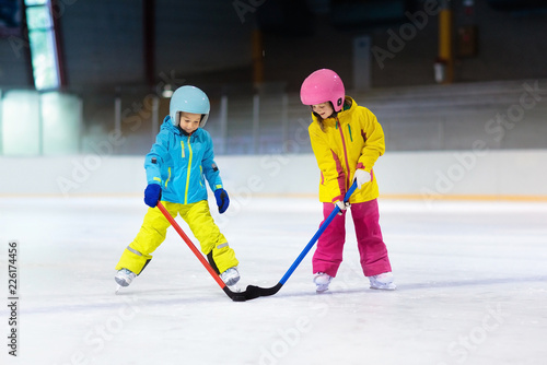 Children play ice hockey. Kids winter sport.