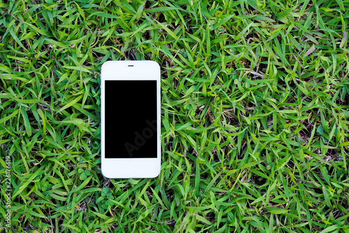 Mobile smart phones on green grass background.