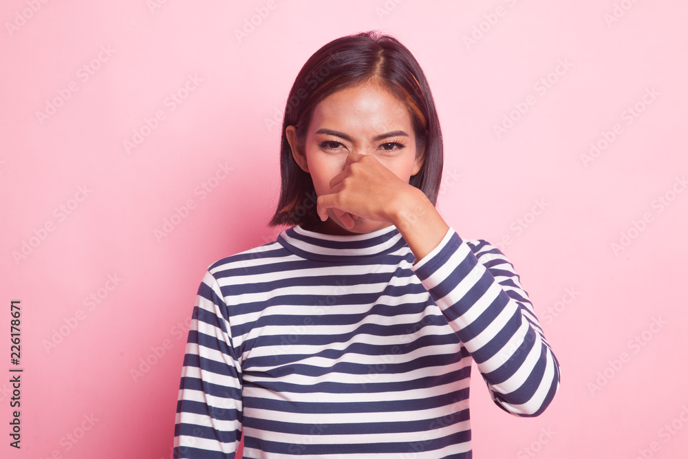 Young Asian woman holding her nose because of a bad smell. Young Asian woman holding her nose because of a bad smell.
