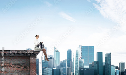 Businesswoman or accountant on brick roof against modern city sc