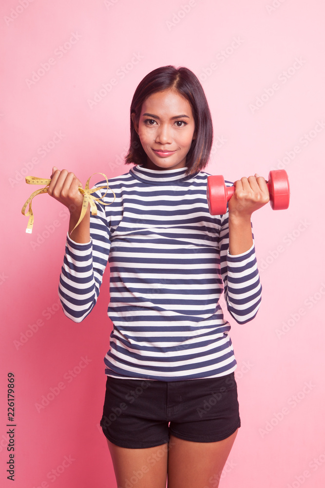 Healthy Asian woman with dumbbells and measuring tape. Healthy Asian woman with dumbbells and measuring tape.