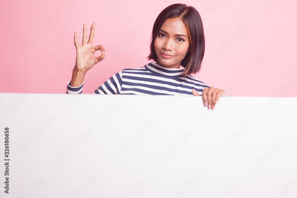 Fototapeta premium Young Asian woman show OK with blank sign.