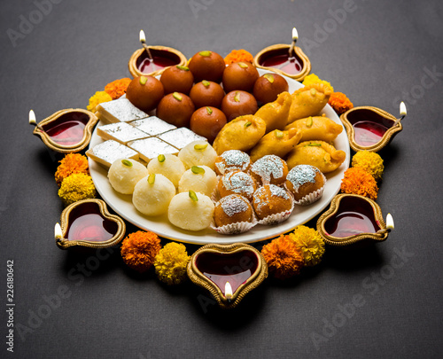 Diwali Rangoli made using oil lamp, flowers and plate photo