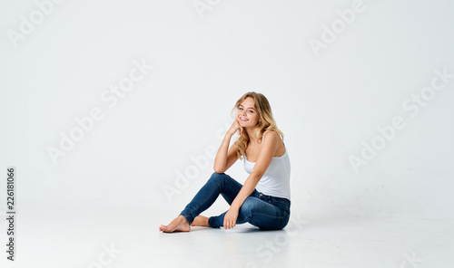 woman sitting on the floor in a white t-shirt on an isolated background