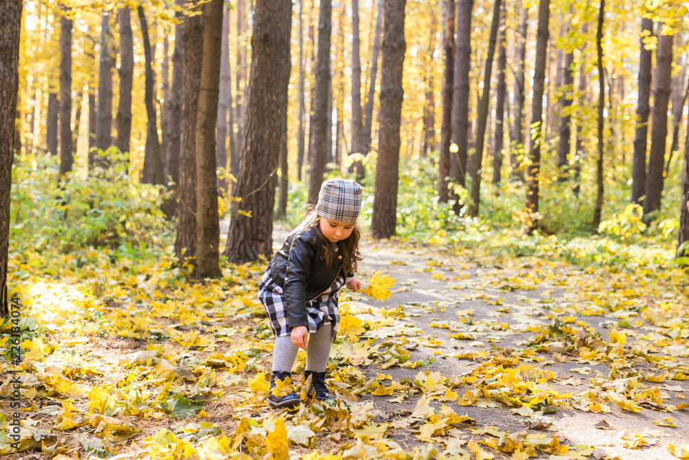Fototapeta premium Child, nature and family concept - happy little girl laughing and playing in the autumn on the nature walk outdoors