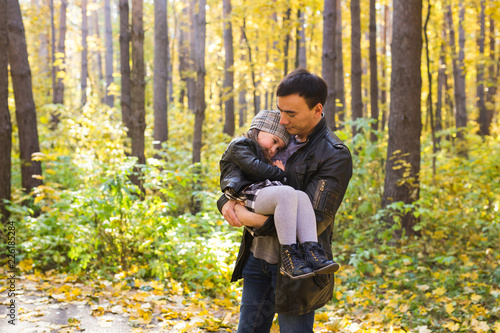 Family, autumn, people concept - father and daughter walking in autumn park. Daughter on dad's hands © satura_