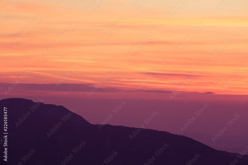 A beautiful, minimalist scenery of mountain sunset in purple tones. Abstract, colorful mountain landscape. Tatra mountains in Slovakia, Europe.