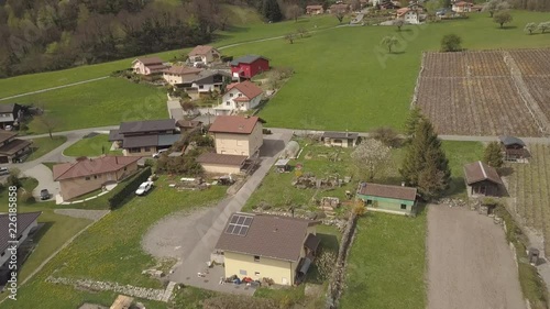 Aerial drone shot over the homes of Lavey Les Bains underneath a tall snowy mountain peak in Switzerland. photo