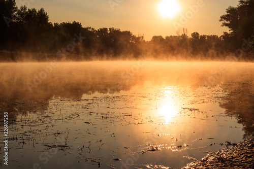 View of river in the mist at sunrise. Fog over river at morning