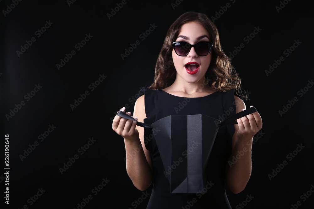 Happy woman with shopping bag on black background Happy woman with shopping bag on black background