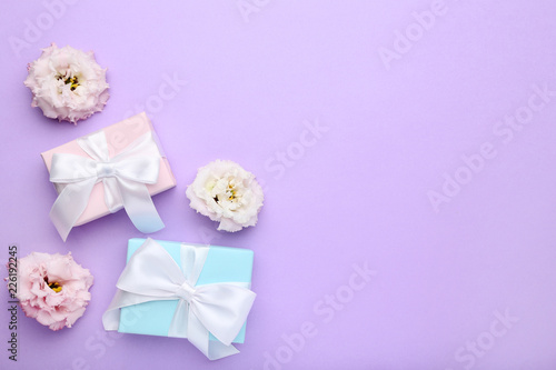 Gift boxes with ribbon and eustoma flowers on purple background © 5second