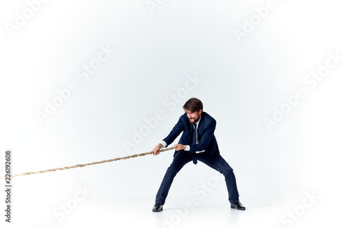 man in a suit pulls the rope on an isolated background