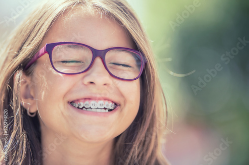 Portret szczęśliwa uśmiechnięta nastoletnia dziewczyna z stomatologicznymi brasami i szkłami