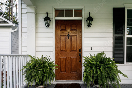 Photo Brown Wood Front Door of a White Siding Southern House