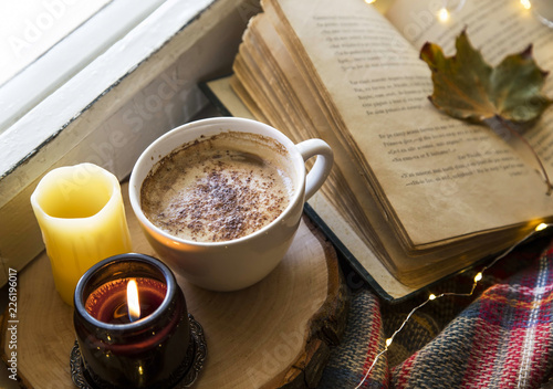 Cozy still life autumn coffee cup with scented candle and old book, fall cozy lifestyle