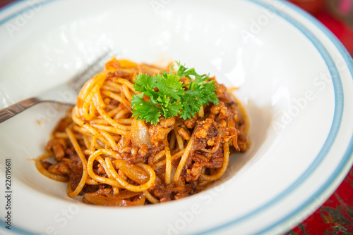 Top view of spaghetti with ketchup and pork chop on wooden table