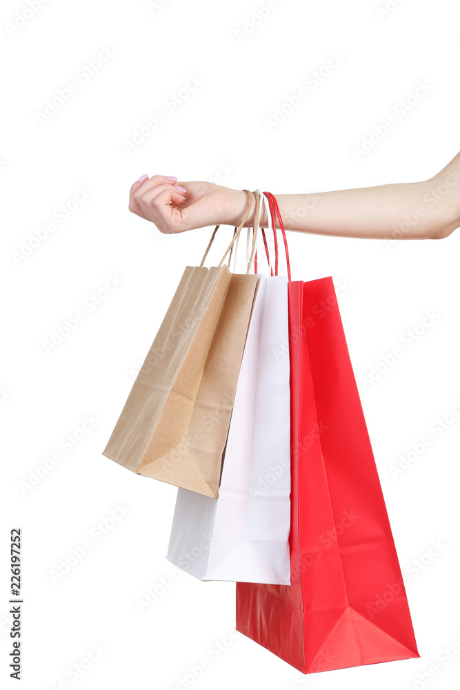 Female hand holding colorful shopping bags on white background