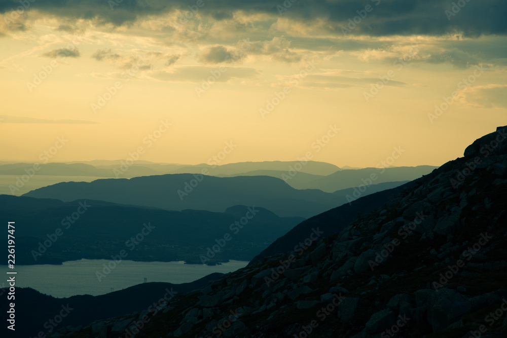 A magnificent sunset scenery over the fjords in Norway. A beautiful autumn landscape in Folgefonna national park. Dramatic sky and mountains.