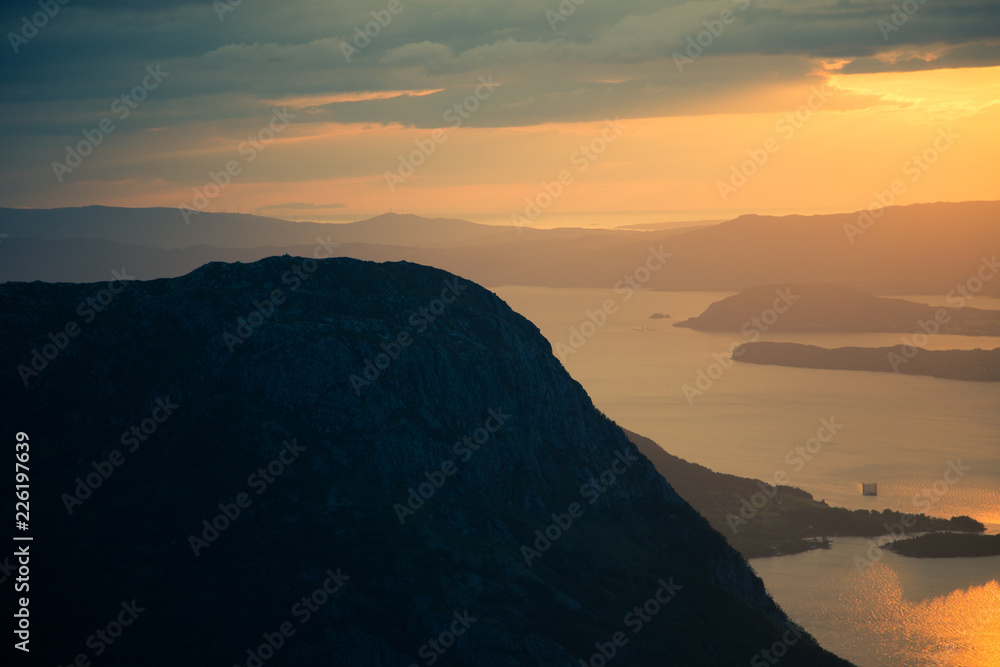 A magnificent sunset scenery over the fjords in Norway. A beautiful autumn landscape in Folgefonna national park. Dramatic sky and mountains. A magnificent sunset scenery over the fjords in Norway. A beautiful autumn landscape in Folgefonna national park. Dramatic sky and mountains.