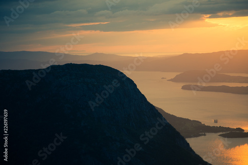 A magnificent sunset scenery over the fjords in Norway. A beautiful autumn landscape in Folgefonna national park. Dramatic sky and mountains.