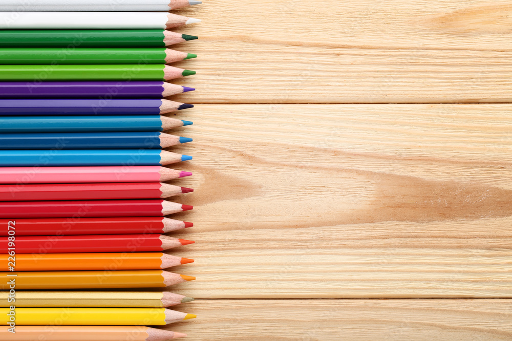 Colored pencils on brown wooden table Colored pencils on brown wooden table