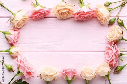 Pink and beige roses on wooden table