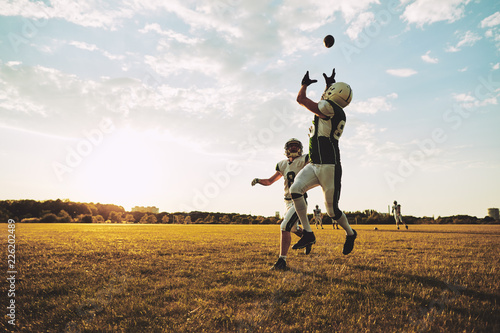 American football player catching a pass during practice