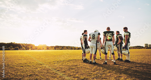 American football players talking together during an afternoon p