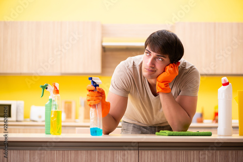 Single man cleaning kitchen at home