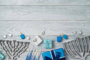 Jewish holiday Hanukkah background with menorah, spinning top and gift box on wooden table