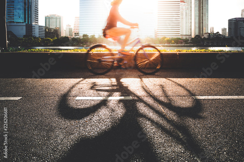A young women going to work place by her bike in morning.