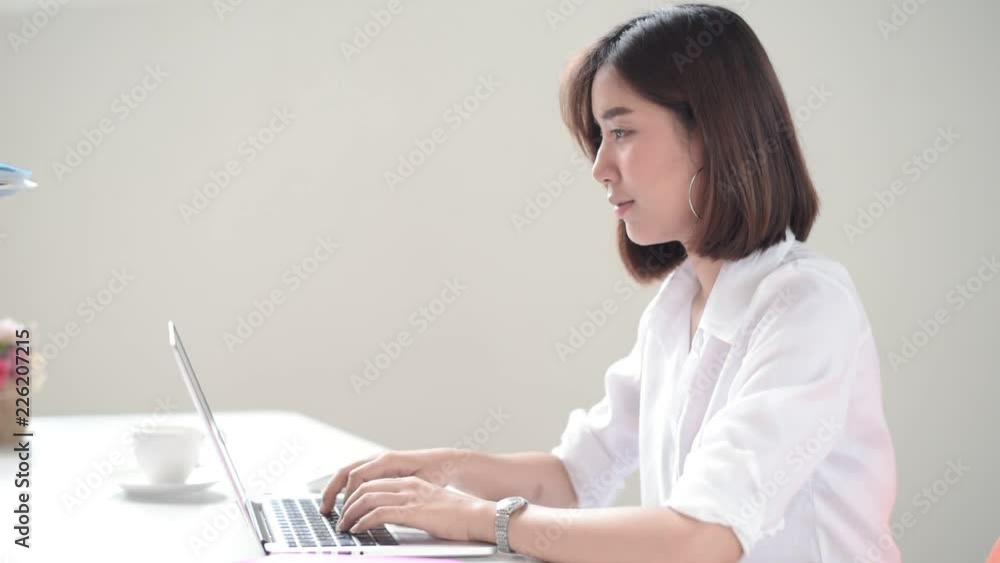 Young Asian woman working with computer and recieve file folder from another colleague Young Asian woman working with computer and recieve file folder from another colleague