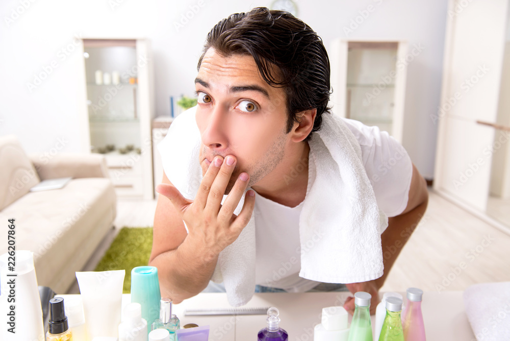 Young handsome man in the bathroom in hygiene concept Young handsome man in the bathroom in hygiene concept