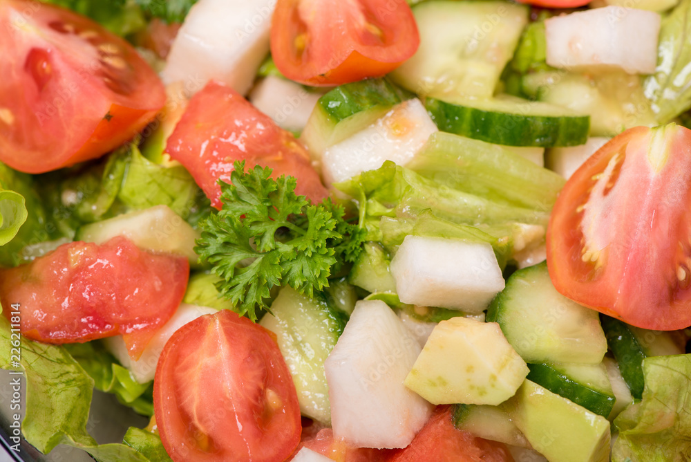 Delicious salad of vegetables, turnips, cucumber, tomato, avocado and parsley on a white background Delicious salad of vegetables, turnips, cucumber, tomato, avocado and parsley on a white background