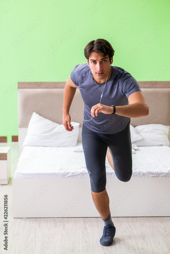 Young handsome man doing morning exercises in the hotel room Young handsome man doing morning exercises in the hotel room
