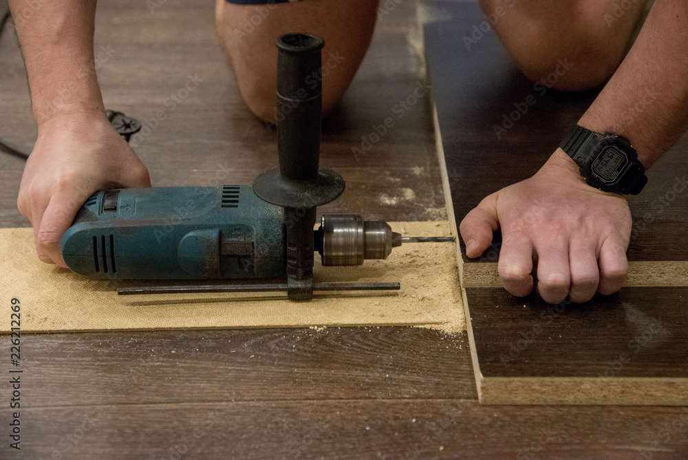 Assembling a wooden cabinet at home using a drill and a screwdriver