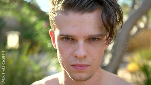 A close up of a young attractive white man with green eyes looking very mad, upset and angry. photo