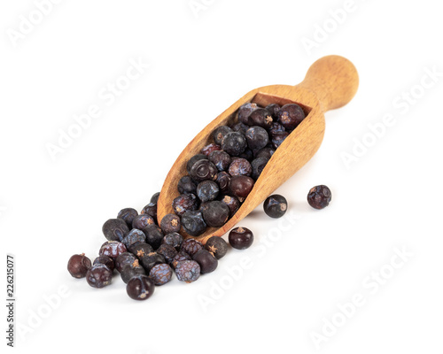 Dried juniper berries in wooden spoon isolated on white
