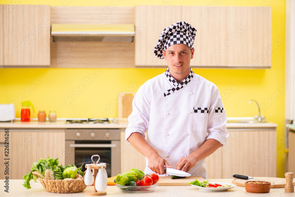 Young professional cook preparing salad at kitchen Young professional cook preparing salad at kitchen