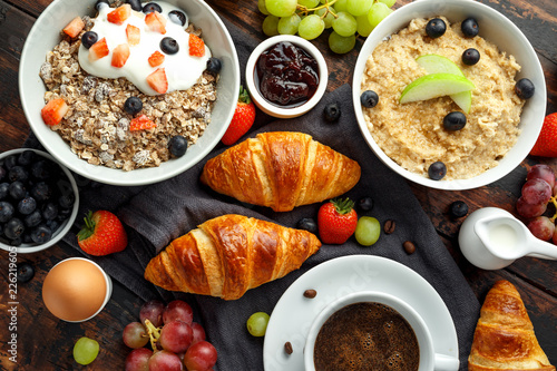 Healthy Breakfast served with coffee, orange juice, croissants, egg, cereals, oatmeal and fruits.