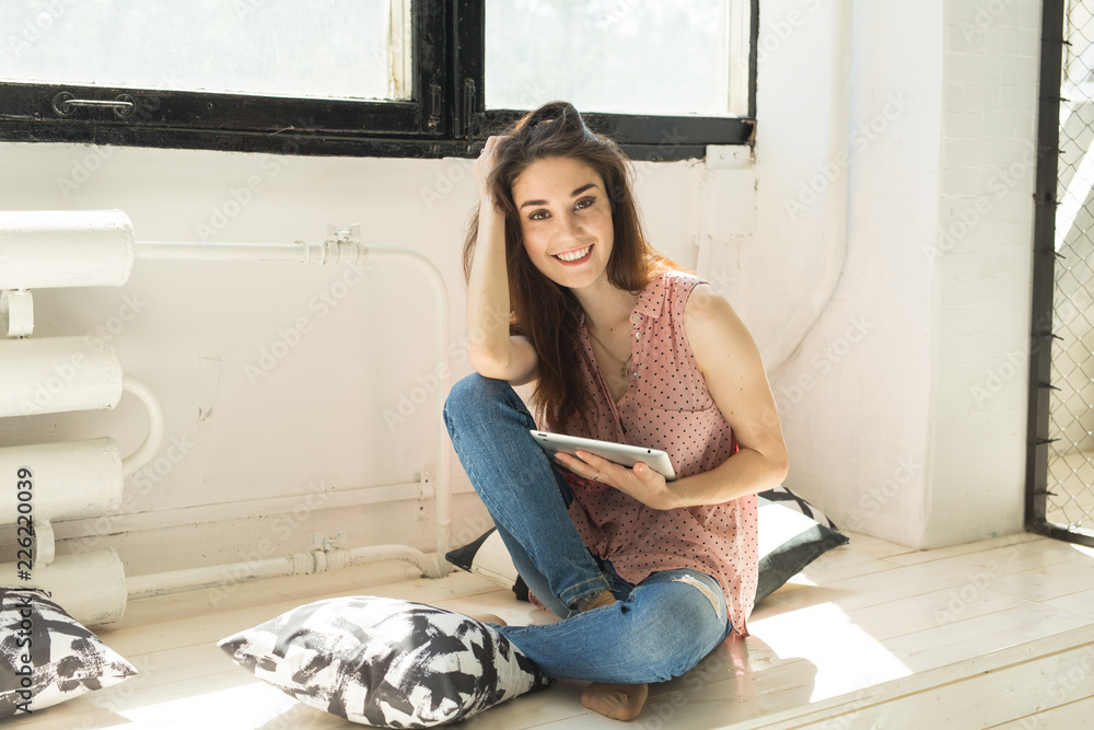 Leisure, technology and people concept - young brunette woman using tablet at home Leisure, technology and people concept - young brunette woman using tablet at home