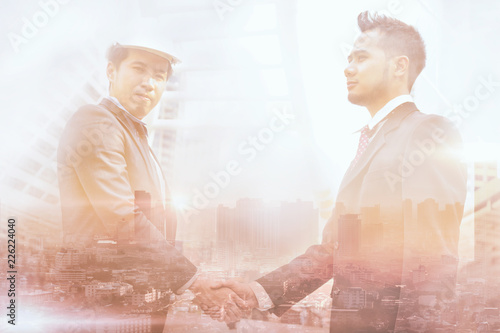 Double exposure of two businessmen checking hand