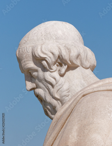 Plato the ancient greek philosopher in deep thoughts portrait on blue sky background, detail of marble statue in Athens Greece
