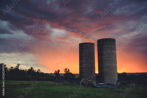 sunset over farmlands, silos at sunset