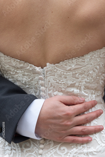 bride with groom's hand on her back