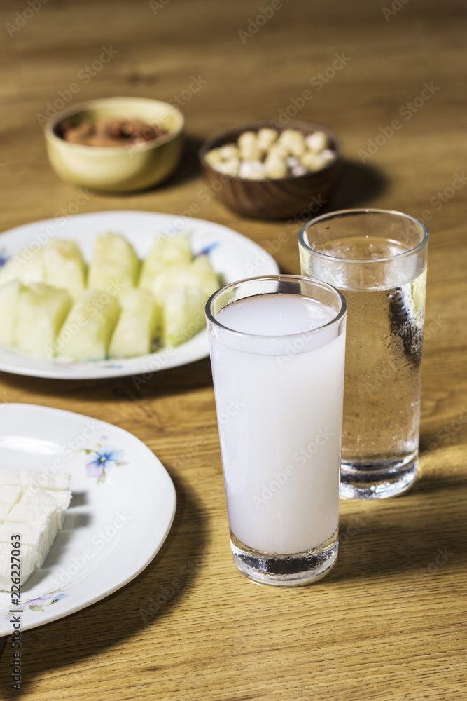 Turkish raki with melon cookies on wooden table Turkish raki with melon cookies on wooden table