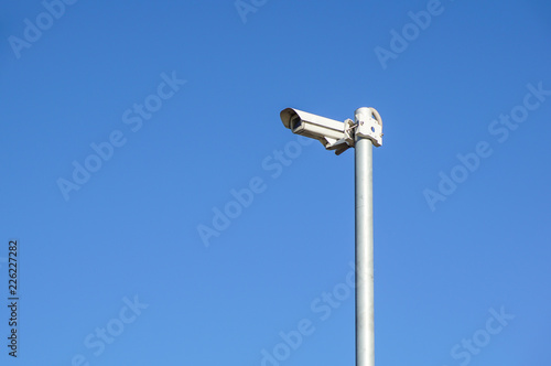 CCTV security camera and surveillance on a pole against the backdrop of blue sky
